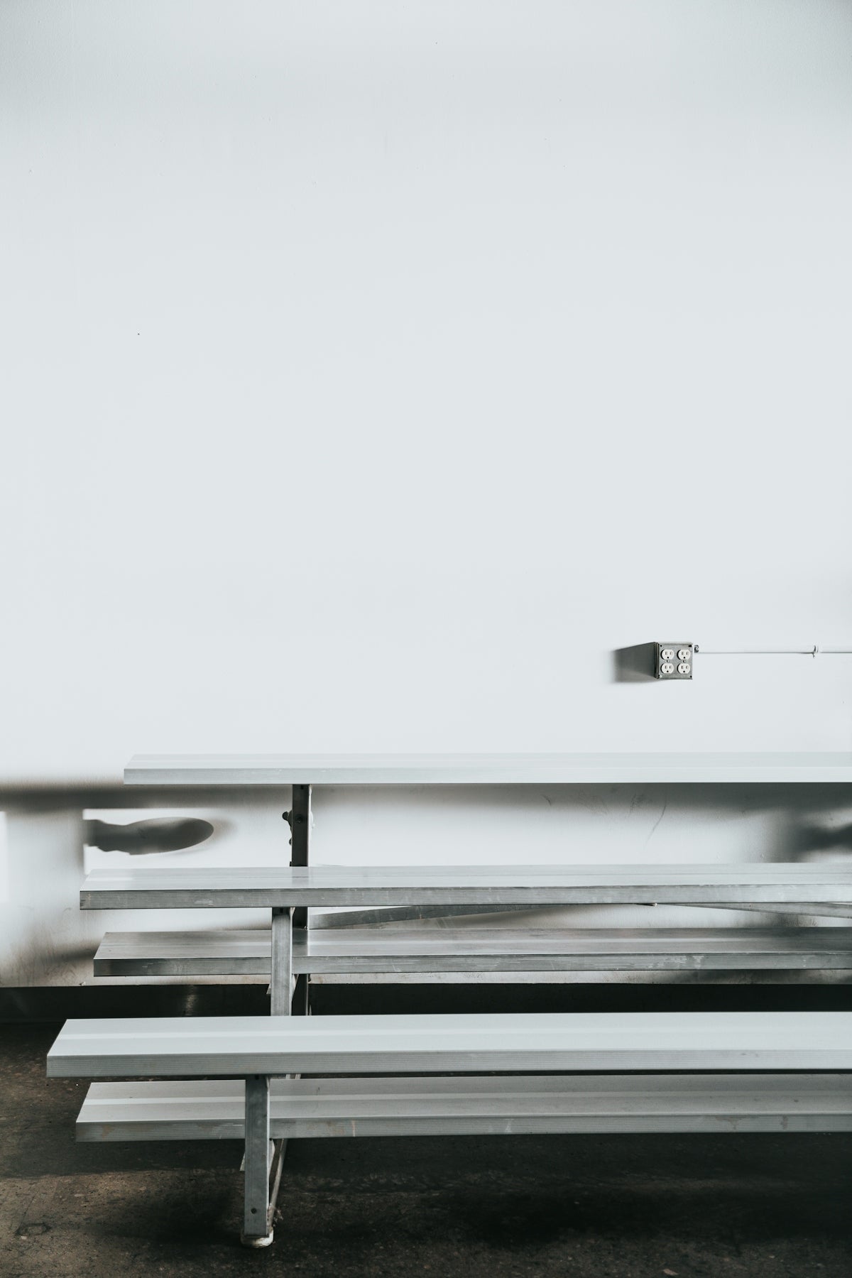 gray bench near white wall