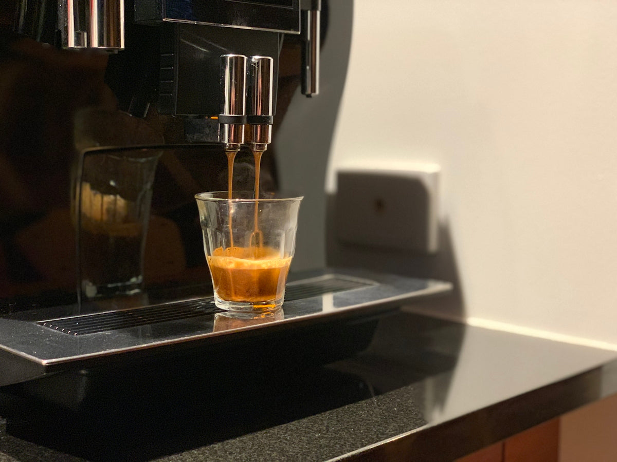clear drinking glass on black and silver coffee maker