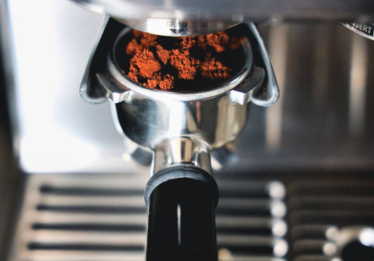 a close up of a coffee machine with red stuff in it