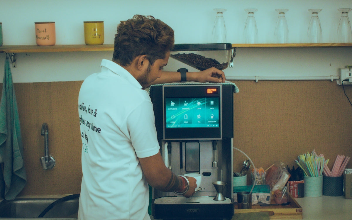 a man standing in front of a coffee machine