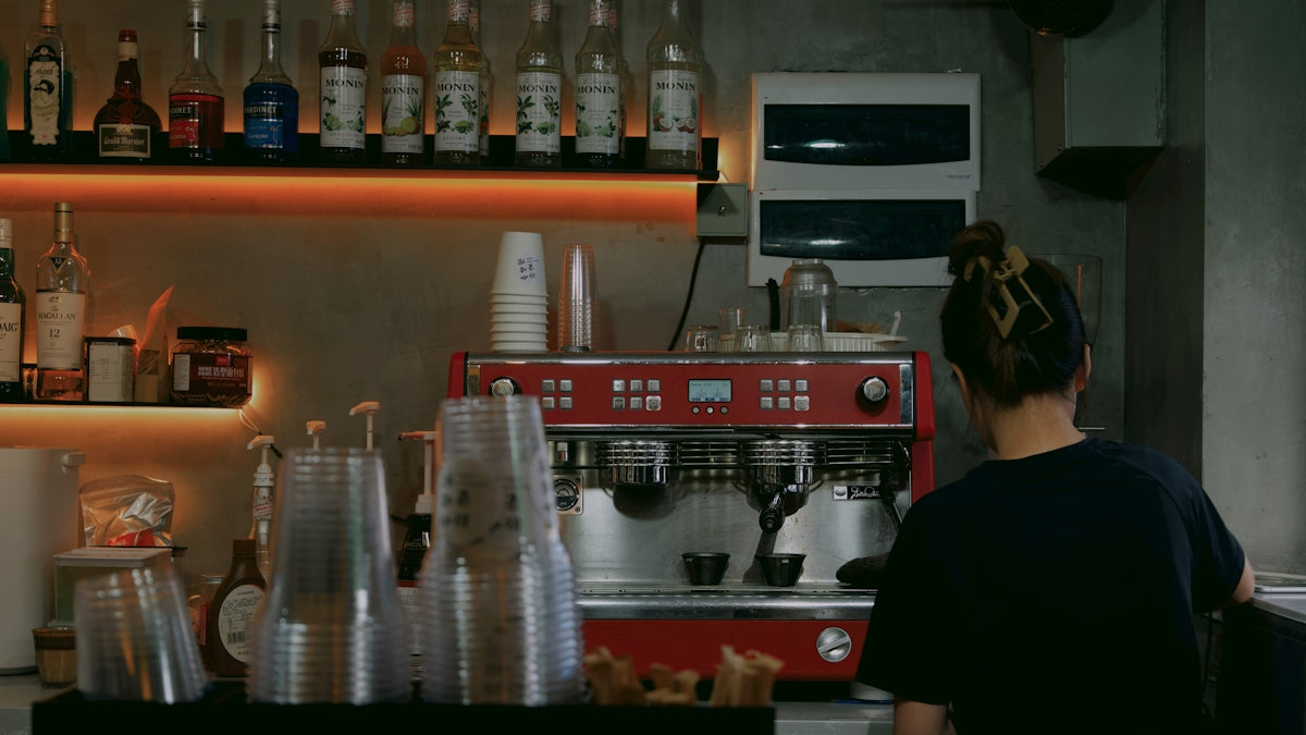 a woman standing in front of a coffee machine