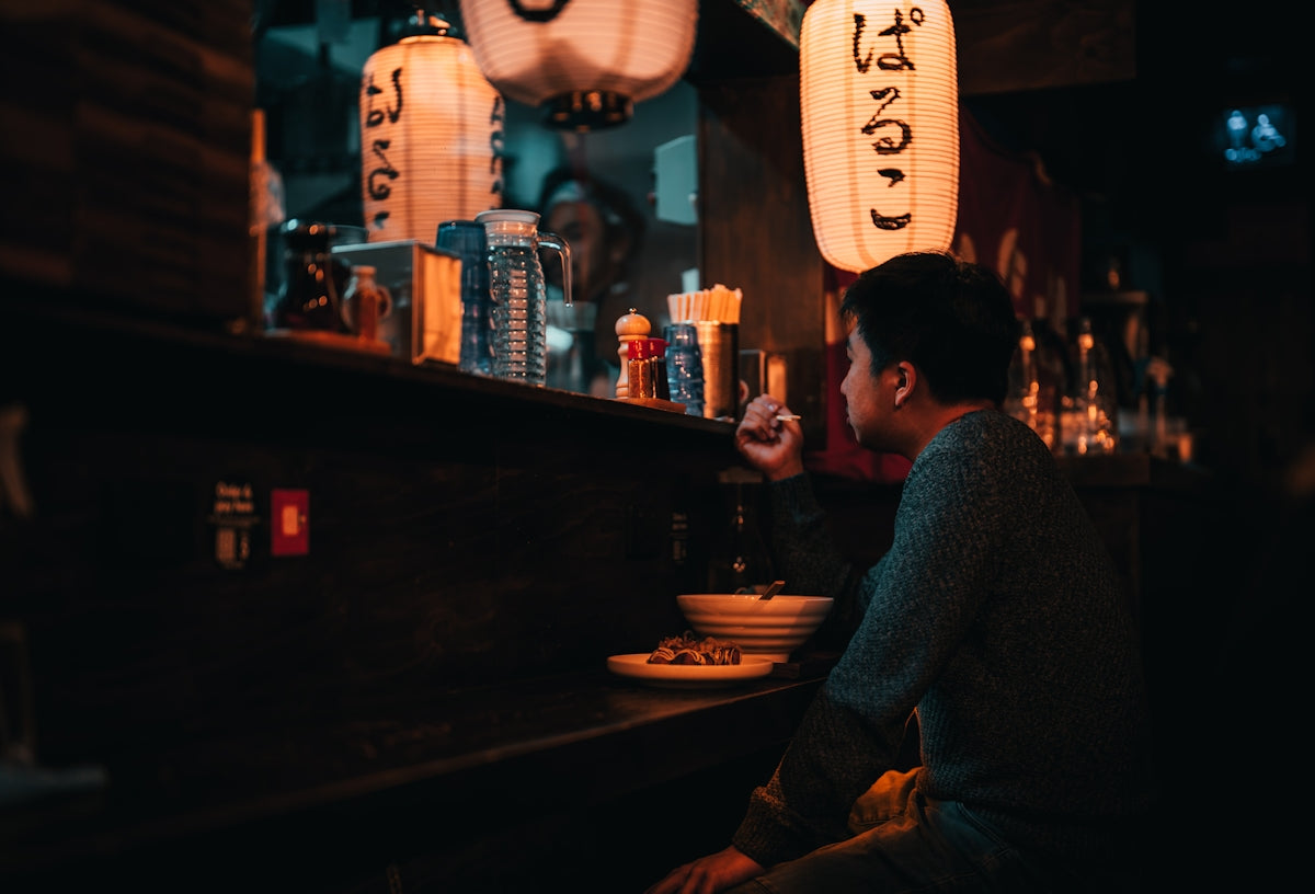 a man sitting at a bar with a plate of food in front of him