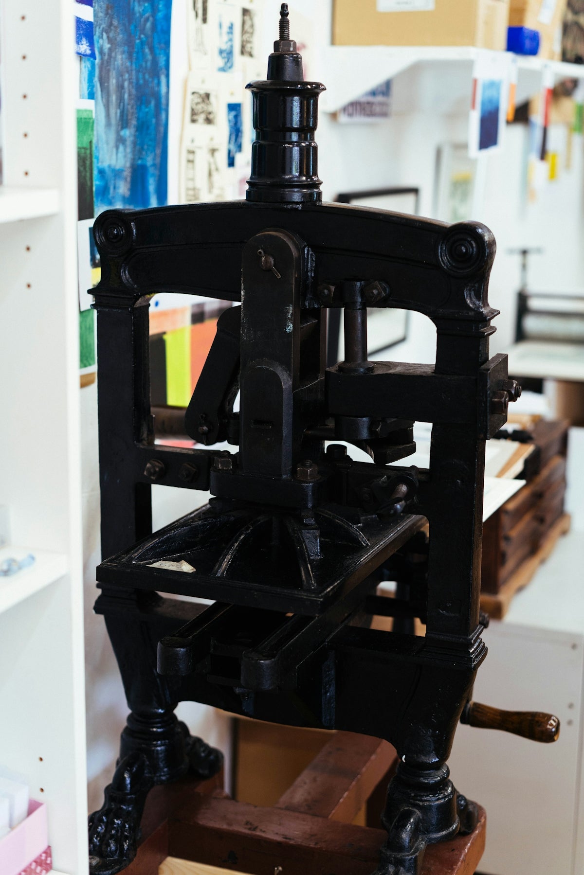 A vintage printing press is shown indoors.